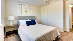 um quarto com uma cama grande e almofadas azuis em Landing - Modern Apartment with Amazing Amenities (ID7595X39) em Ogden