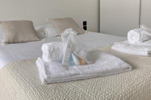 - une pile de serviettes sur le lit dans l'établissement 320 Dolce Vita Suite - Superb apartment, à Suresnes