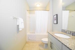 a white bathroom with a toilet and a sink at Landing - Modern Apartment with Amazing Amenities (ID3752) in Atlanta