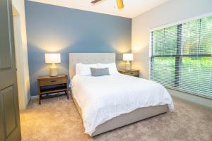 um quarto com uma cama branca e duas mesas com candeeiros em Landing - Modern Apartment with Amazing Amenities (ID3752) em Atlanta