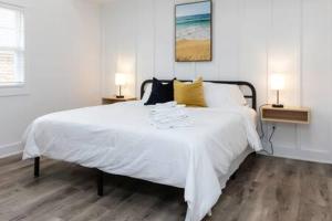 Un dormitorio con una gran cama blanca con dos lámparas. en Ocean Lofts in the Vibe #7 - 5 min walk to beach, en Virginia Beach