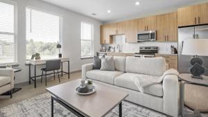 ein Wohnzimmer mit einem Sofa und einer Küche in der Unterkunft Landing - Modern Apartment with Amazing Amenities (ID1208X248) in Charlotte