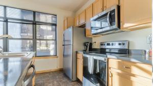 a kitchen with a stainless steel refrigerator and a microwave at Landing - Modern Apartment with Amazing Amenities (ID7898X83) in Milwaukee