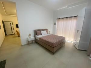 una camera da letto con un letto in una stanza bianca di Apt De Luxe Gallo 2 - Mamelles Dakar a Dakar Altre 40 foto