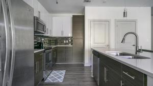 里士滿的住宿－Landing - Modern Apartment with Amazing Amenities (ID6167X30)，厨房配有水槽和不锈钢冰箱