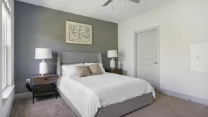 里士滿的住宿－Landing - Modern Apartment with Amazing Amenities (ID6167X30)，卧室配有白色的床和带灯的2个床头柜。