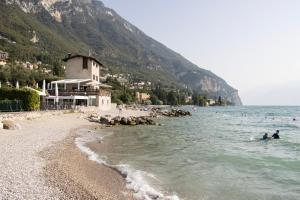 a group of people swimming in the water on a beach at Casa Marsilva - holiday apartment in old town centre, near the lake in Toscolano Maderno