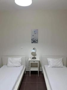2 camas en una habitación con una mesa y una lámpara en Sunset Seafront Home, en Panormos Rethymno