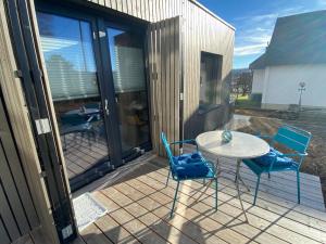 een terras met een tafel en stoelen bij Auf Wolke 7 - Gäste-Studio im Mini House in Aeschi