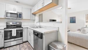 eine Küche mit einer Spüle und einem Herd Top-Backofen in der Unterkunft Landing - Modern Apartment with Amazing Amenities (ID8245X00) in Winston-Salem
