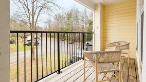 eine Veranda mit zwei Stühlen und einem Zaun in der Unterkunft Landing - Modern Apartment with Amazing Amenities (ID8245X00) in Winston-Salem