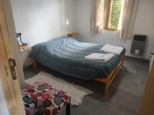 a bedroom with two beds with towels on them at Complejo Turístico PET Friendly Los Abuelos- Cabaña ENCANTO NATURAL. in Cholila