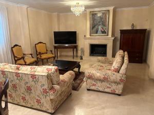 a living room with two couches and a television at Villa de lujo en Torremolinos in Torremolinos