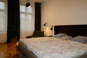 een slaapkamer met een bed, een stoel en een raam bij Zentrales hochwertiges Gründerzeit-Apartment Thomasius in Leipzig