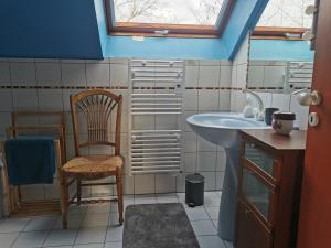 a bathroom with a sink and a chair at Studio spacieux, route des vins in Rosheim +21 photos