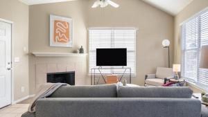 een woonkamer met een bank en een televisie bij Landing - Modern Apartment with Amazing Amenities (ID8246X10) in Tulsa