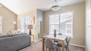 een woonkamer met een bank en een tafel en stoelen bij Landing - Modern Apartment with Amazing Amenities (ID8246X10) in Tulsa