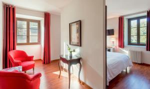 ジェドルにあるロジ オテル ラ ブレシェ ドゥ ローランドのベッド1台、椅子、鏡が備わる客室です。