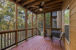 a screened porch with a ceiling fan and a table and chairs at Deer Valley in Branson