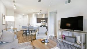 een woonkamer met een bank en een tv en een keuken bij Landing - Modern Apartment with Amazing Amenities (ID3561X40) in Austin