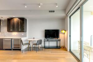 a kitchen with a table and chairs and a tv at Landing - Modern Apartment with Amazing Amenities (ID4772X11) in Dallas