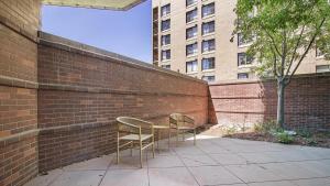 2 Stühle und ein Tisch vor einer Ziegelwand in der Unterkunft Landing Modern Apartment with Amazing Amenities (ID9265X68) in Denver