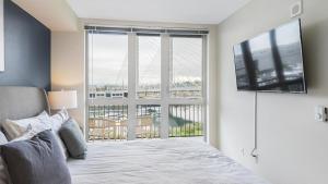 1 dormitorio con 1 cama y ventana grande con TV en Landing Modern Apartment with Amazing Amenities (ID8925X56) en Tacoma