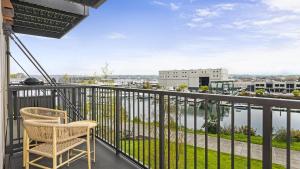 a balcony with a chair and a view of the water at Landing Modern Apartment with Amazing Amenities (ID8925X56) in Tacoma