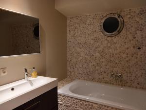 un bagno con vasca, lavandino e specchio di Bed in Boat a Ypres