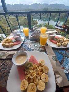 a table with two plates of food and orange juice at Casa Encuentro Ecolodge in Guatapé