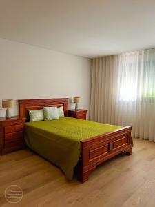 een slaapkamer met een groot bed met een groene sprei bij Casa Couto Do Souto in Souto