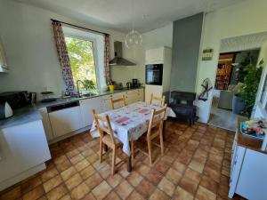 cocina y comedor con mesa y sillas en Les Glycines en Gouvy
