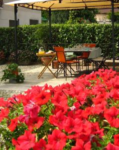 La Mansarda Dell'Artista في Candelo: حفنة من الزهور الحمراء أمام طاولة