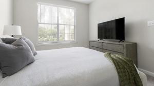 a bedroom with a bed and a flat screen tv at Landing - Modern Apartment with Amazing Amenities (ID1374X806) in Charlotte