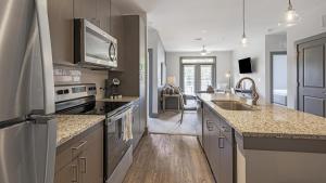 a kitchen with a sink and a stove top oven at Landing - Modern Apartment with Amazing Amenities (ID9684X38) in Flowery Branch