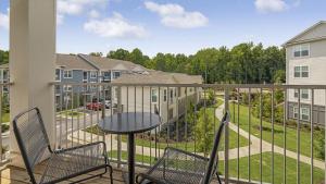 a balcony with two chairs and a table at Landing - Modern Apartment with Amazing Amenities (ID9684X38) in Flowery Branch