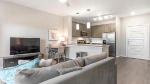 uma sala de estar com um sofá e uma cozinha em Landing - Modern Apartment with Amazing Amenities (ID7253X29) em San Antonio