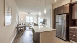 een keuken met een roestvrijstalen koelkast en een tafel bij Landing - Modern Apartment with Amazing Amenities (ID7823X09) in Miami