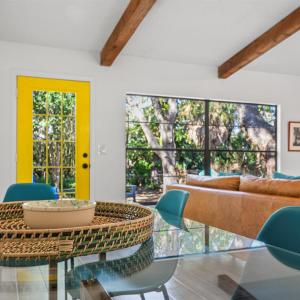 Modern Vacation home near Siesta Key & Downtown في ساراسوتا: غرفة طعام مع طاولة زجاجية وكراسي زرقاء