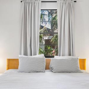 uma cama com duas almofadas listradas em frente a uma janela em Modern Vacation home near Siesta Key & Downtown em Sarasota