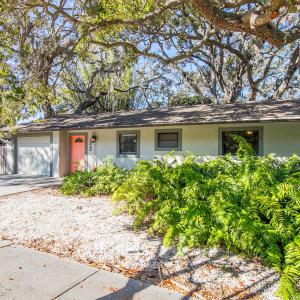 ein Haus mit einer roten Tür und einigen Pflanzen in der Unterkunft Modern Vacation home near Siesta Key & Downtown in Sarasota