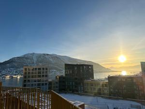 een uitzicht op een stad met de zon in de lucht bij TheNorthernExplorer Penthouse in Tromsø