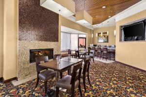 uma sala de jantar com mesas e cadeiras e uma lareira em Hotel RL Cleveland Airport West em North Olmsted