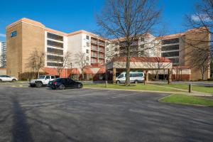 a parking lot with cars parked in front of a building at Hotel RL Cleveland Airport West in North Olmsted