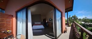 een kamer met een bed en een balkon met uitzicht bij Hospedaria Noite Lunar in Praia do Rosa