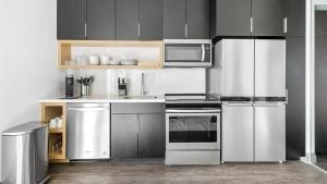 cocina con electrodomésticos de acero inoxidable y microondas en Landing - Modern Apartment with Amazing Amenities (ID1381X632), en The Colony