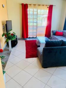 un soggiorno con divano e tappeto rosso di Yonga Apartment a Kisumu