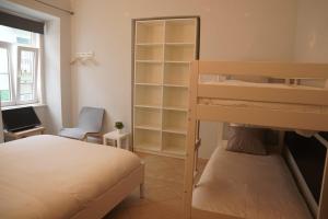 - une chambre avec des lits superposés, un bureau et une chaise dans l'établissement Bisengototo Homestay, à Lisbonne