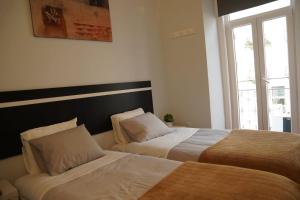 2 camas en una habitación con ventana en Bisengototo Homestay, en Lisboa