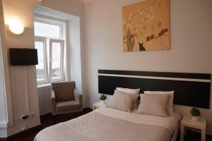 - une chambre avec un lit blanc et une chaise dans l'établissement Bisengototo Homestay, à Lisbonne
